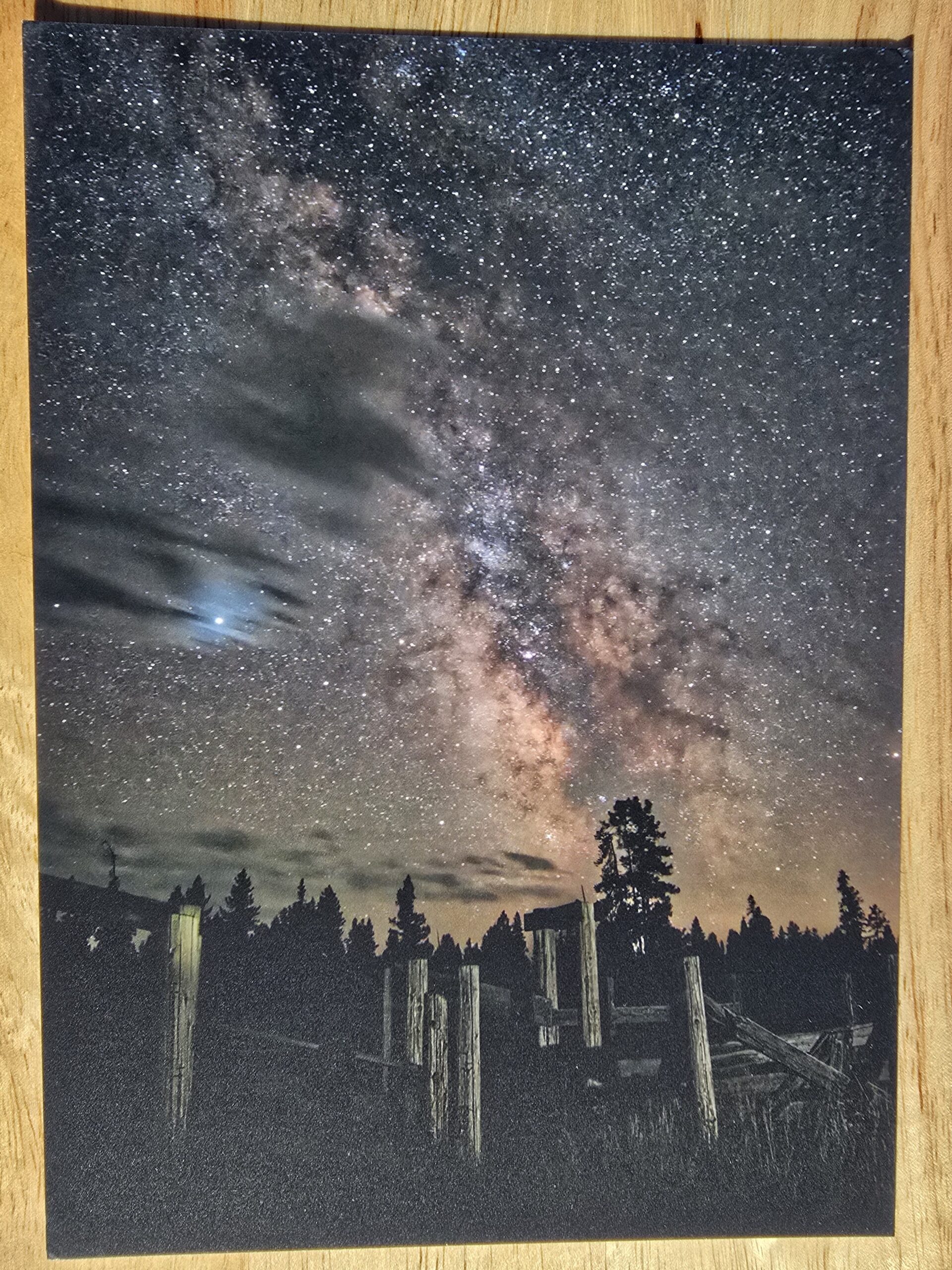 Postcard featuring Milky Way Over Corral displayed flat on a table